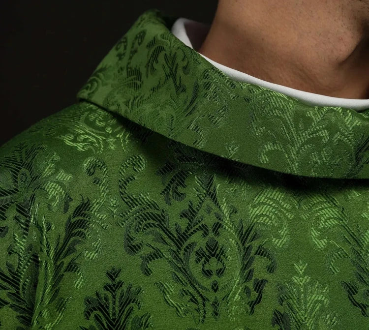 Green Chasuble with IHS embroidery on decorative fabric — close-up detail
