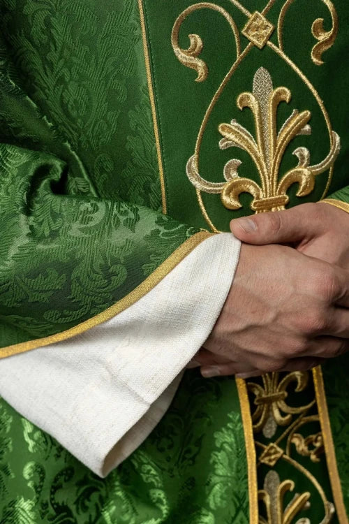 Green Chasuble with IHS embroidery on decorative fabric — close-up detail