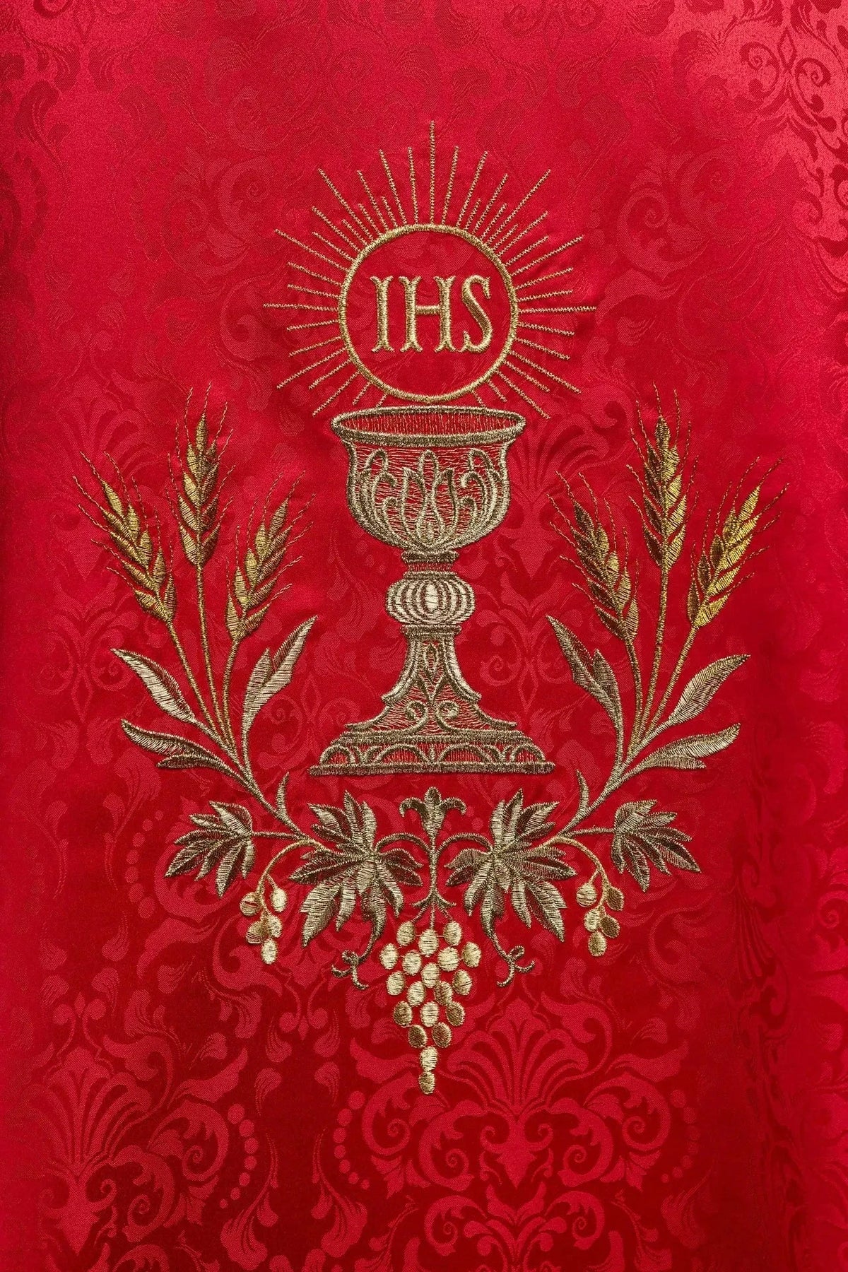 Rote Jacquardkasel mit Kelch und Hostie — Nahaufnahme der Stickerei
