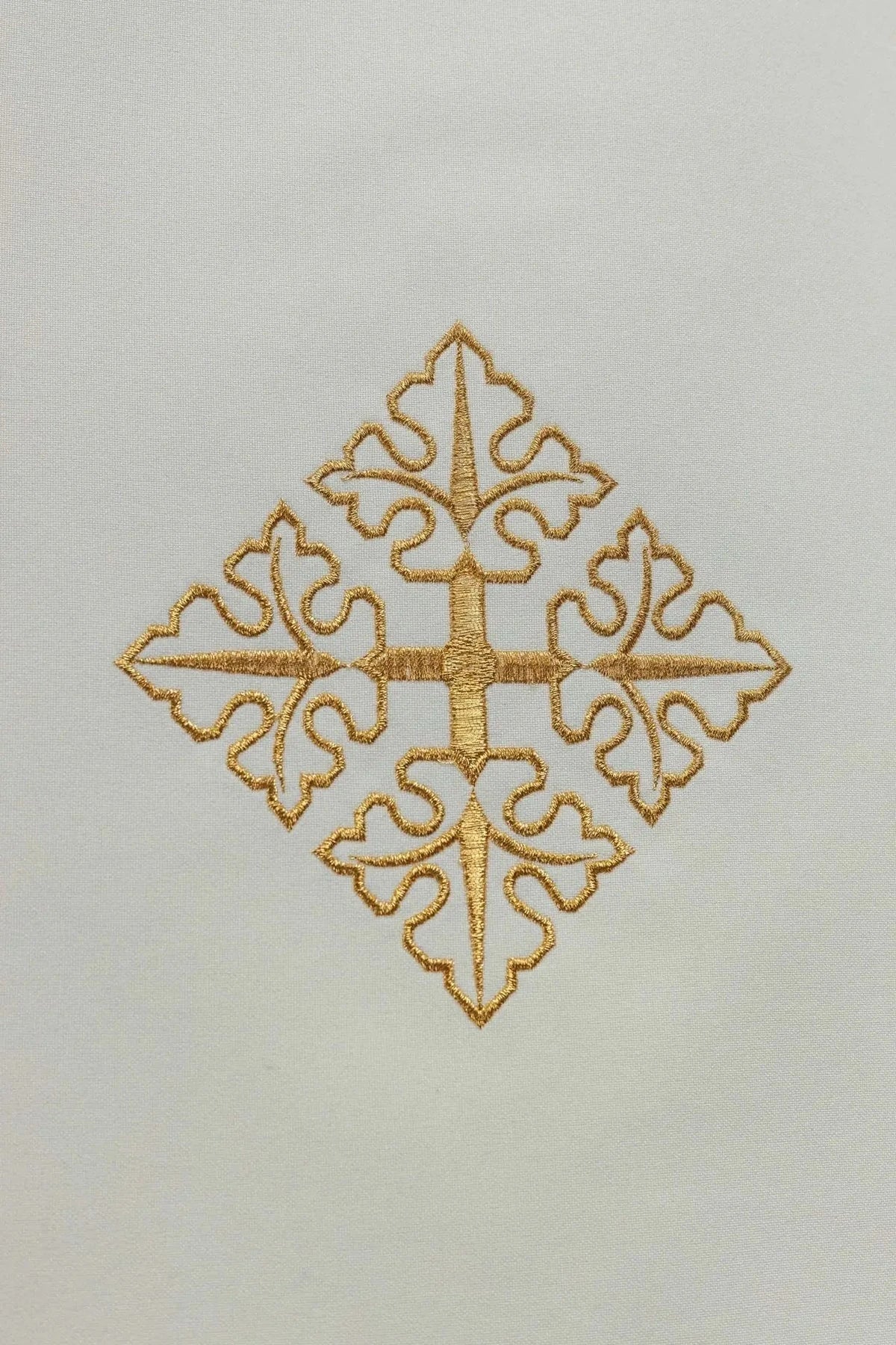 Close-up of the gold cross and botanical ornament
